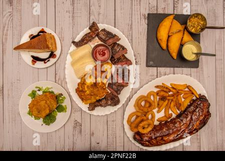 Una combinazione di piatti meravigliosi della cucina colombiana più parsera con carni al carbone, empanadas di mais con salse al peperoncino, una porzione di quesillo A. Foto Stock