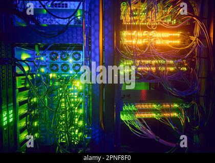 Server illuminati e cavi per computer nella sala server Foto Stock
