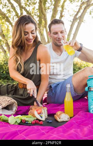 Giovane avente picnic nel parco Foto Stock