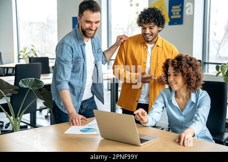 Lavoro di squadra. Team aziendale creativo, persone di successo di diverse nazionalità, lavorare insieme a un progetto in un ufficio moderno, guardare la presentazione, discutere idee, brainstorming, comunicare Foto Stock