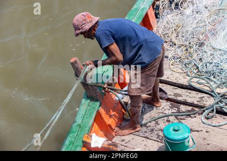 SAMUT PRAKAN, THAILANDIA, MAR 14 2023, Un pescatore lavora su una barca da pesca Foto Stock