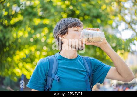 Uomo che tiene un caffè ghiacciato in una tazza di plastica Foto Stock