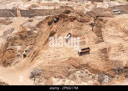 vaste opere di terra in cantiere con più macchinari industriali pesanti. vista aerea. Foto Stock