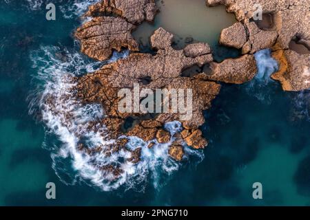 Vista aerea, tramonto a Praia do Evaristo, rocce e scogliere in Algarve, Portogallo Foto Stock