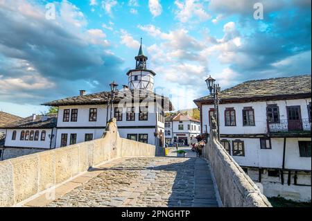 TRYAVNA, BULGARIA. La torre dell'orologio e il ponte in pietra nel centro storico nel complesso architettonico tradizionale. Rinascita architettura bulgara Foto Stock