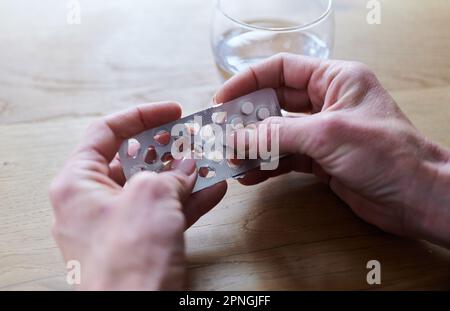 Berlino, Germania. 17th Apr, 2023. Una donna prende un tablet dalla confezione. Credit: Annette Riedl/dpa/Alamy Live News Foto Stock