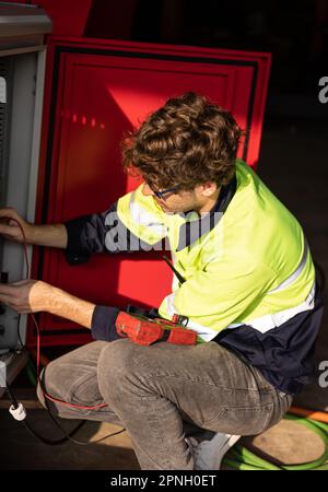 L'automazione del controllo da parte di tecnici robotici funziona entro i limiti accettati, verificando le tensioni di esercizio e le configurazioni elettriche. Percorso della fabbrica robotica Foto Stock