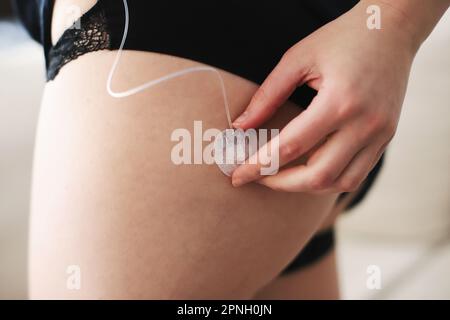 Donna che collega la pompa per insulina al set per infusione nel suo corpo Foto Stock