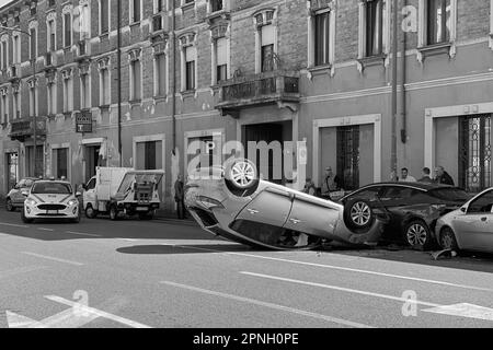 Cremona, Italia - 18th aprile 2023 ha appena fatto rotolare l'auto in crash dopo un incidente, poliziotto che aiuta con il traffico Foto Stock