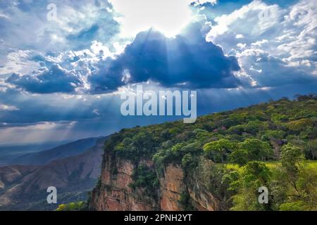 Vista spettacolare delle scogliere con foresta pluviale, raggi solari che cadono attraverso le nuvole di tempesta, Chapada dos Guimaraes, Mato Grosso, Brasile, Sud America Foto Stock