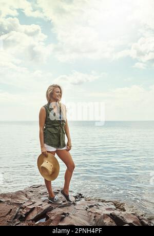 Amarlo fuori nel mezzo del nulla. una giovane donna attraente che trascorre una giornata al lago. Foto Stock