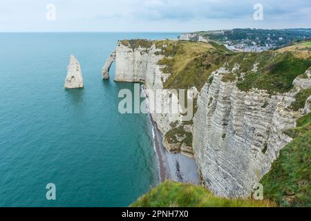 Vista panoramica della costa di Etretat in Normandia Francia con mare calmo contro il cielo drammatico Foto Stock