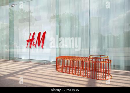 Ho Chi Minh City, Vietnam - 7 aprile 2023: Logo HM su una vetrina del negozio di moda veloce. Popolare segno di marca di abbigliamento fuori da un centro commerciale Foto Stock