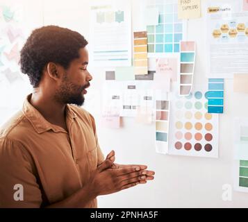 Uomo nero, tavolozza di colori e pianificazione nel design, brainstorming o strategia sulla parete in ufficio. Disegnatore grafico maschile creativo e premuroso Foto Stock