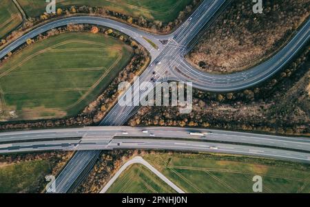 Una vista aerea dall'alto di un'intersezione trafficata di più autostrade che attraversano la campagna Foto Stock