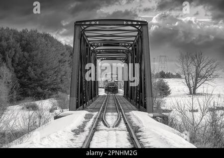 Treno che attraversa un ponte a traliccio a doppia campata costruito nel 1893 attraversando il fiume Mississippi in inverno a Galetta, Ontario, Canada Foto Stock