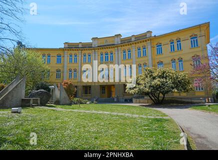 Busseto, Italia: Edificio giallo della scuola e memoriale di guerra in una giornata di sole Foto Stock