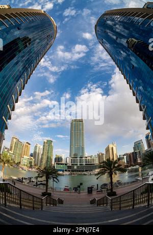 Vista grandangolare di edifici di appartamenti alti e hotel sull'acqua a Dubai Marina negli Emirati Arabi Uniti Foto Stock