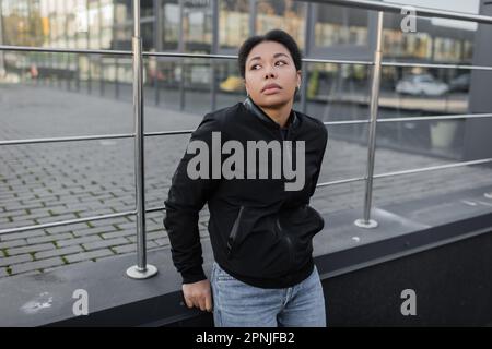 Giovane donna multirazziale con crisi psicologica in piedi sulla strada urbana, immagine stock Foto Stock