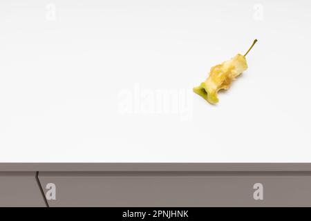 un nucleo di mela si trova sul bordo del tavolo. il moncone è sul tavolo. core apple. Foto di alta qualità Foto Stock