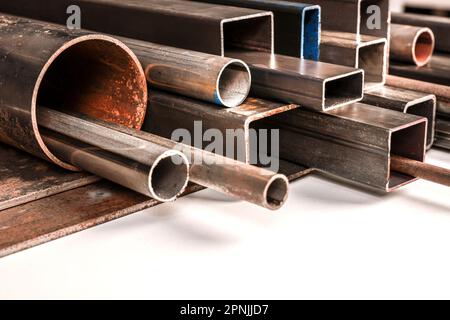 tubi metallici di varie forme e dimensioni su sfondo bianco. Foto Stock