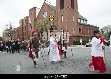 I parrocchiani di varie chiese camminano insieme le stazioni della Croce il Venerdì Santo a Brooklyn, New York. Le stazioni della Croce, note anche come Via Crucis, commemorano la passione e la morte di Gesù sulla croce. Ci sono 14 stazioni che raffigurano ciascuna un momento del suo viaggio verso il Calvario, di solito attraverso l'arte sacra, le preghiere e le riflessioni. La pratica iniziò mentre i pii pellegrini tracciavano il suo cammino attraverso Gerusalemme sulla via dolorosa. Foto Stock