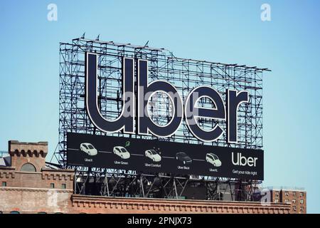 Manhattan, NY - 9 Aprile 2023: Cartellone per il servizio auto Uber di New York City sulla parte superiore dell'edificio Foto Stock
