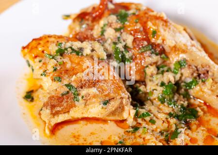 Lo Shkmeruli è un piatto tradizionale georgiano di pollo in salsa all'aglio nel piatto bianco. Cibo Foto Stock