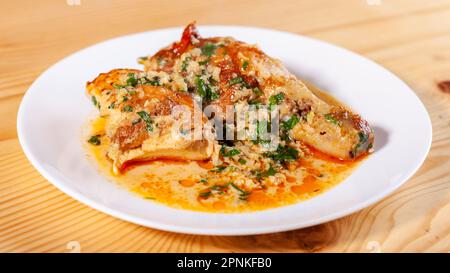 Lo Shkmeruli è un piatto tradizionale georgiano di pollo in salsa all'aglio nel piatto bianco. Cibo Foto Stock