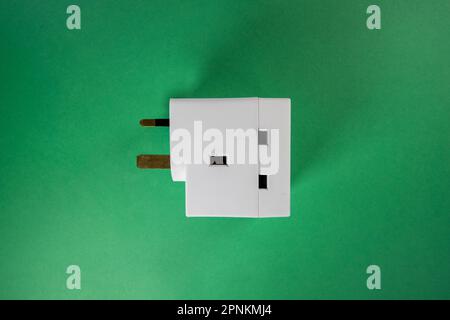 connettore maschio a tre pin per l'uso con presa multipla isolato su sfondo verde scuro Foto Stock