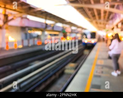 Immagine sfocata della stazione ferroviaria prima del tramonto, skytrain BTS a Bangkok, Thailandia Foto Stock