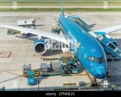 Vietnam Airlines Airbus A350 all'aeroporto internazionale noi Bai (NIA), il principale aeroporto di Hanoi, la capitale del Vietnam. Caricamento dei contenitori di carico Foto Stock