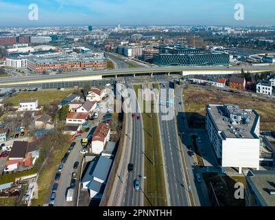 Incrocio multilivello con autostrada a Cracovia, Polonia. Tram e una fermata del tram, auto, attraversamenti pedonali zebra, vista aerea Foto Stock