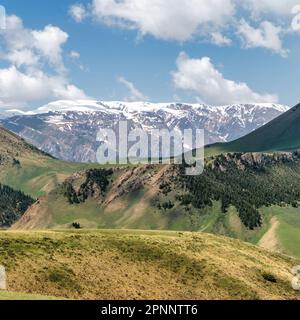 Kirghizistan natura verde paesaggio con vaste montagne. Il Kirghizistan è un paese senza sbocco sul mare situato nell'Asia centrale, noto per la sua aspra e montuosa t Foto Stock