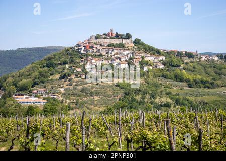 Il villaggio di Motovun, Istria, Croazia e montagne sullo sfondo con un cielo azzurro chiaro Foto Stock