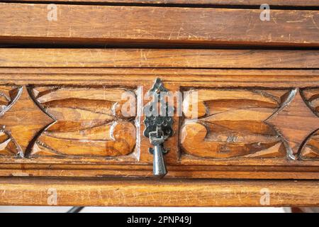 maniglia del cassetto in ferro stile spagnolo sul lato anteriore del cassetto in legno intagliato a mano Foto Stock