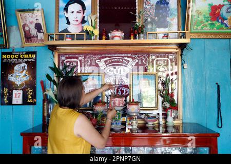 Altare antenato. La venerazione dei morti in casa. Donna che prega. Donna. Tan Chau. Vietnam. Foto Stock