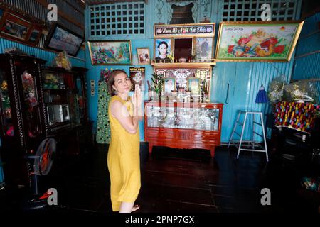 Altare antenato. La venerazione dei morti in casa. Donna che prega. Donna. Tan Chau. Vietnam. Foto Stock