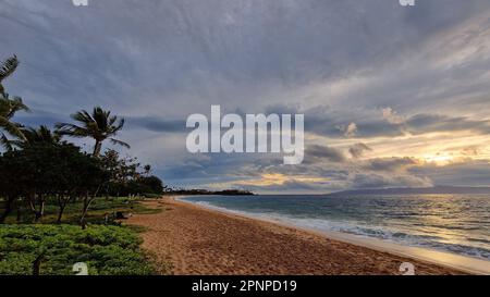 Il cielo nuvoloso sul mare catturato dalla spiaggia sabbiosa di Kaanapali a Maui Foto Stock