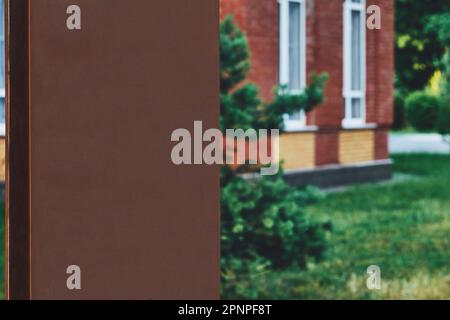 Lavagna marrone per iscrizioni e testi e una casa su un prato verde in una confezione Foto Stock