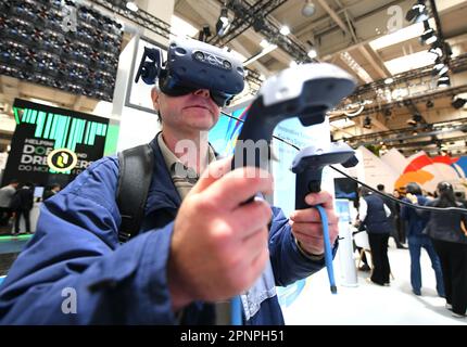 (230420) -- HANNOVER, 20 aprile 2023 (Xinhua) -- Un visitatore viene a conoscenza della piattaforma Internet industriale di Haier COSMOPlat by VR alla Hannover Messe 2023 di Hannover, Germania, 19 aprile 2023. Le aziende cinesi sono competitive nei mercati globali e sono sempre pronte ad apprendere e migliorare, Jochen Koeckler, presidente del consiglio di amministrazione della Deutsche Messe AG, ha commentato mercoledì sulle 800 società cinesi che partecipano alla Hannover Messe 2023. La fiera, una delle più grandi al mondo e che durerà da aprile 17 ad aprile 21, espone più di 4.000 aziende, che presentano soluzioni Foto Stock