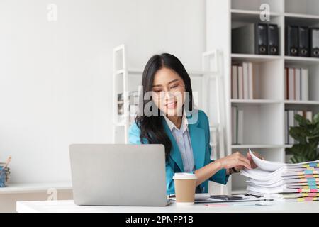 Donna d'affari che lavora in pile di carta per la ricerca e il controllo di documenti su carte presso la scrivania ufficio Foto Stock