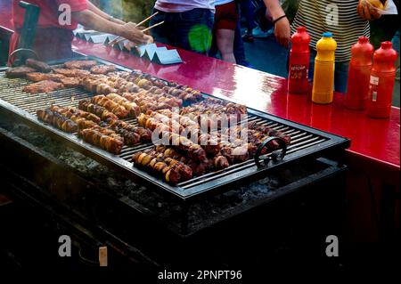 Vista su una griglia su cui spiedini sono preparati su carbone in un festival di strada. Foto Stock
