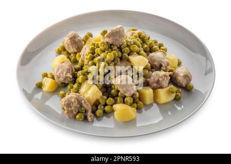 Stufato di piselli e patate con polpette in piatto isolato su bianco con percorso di ritaglio incluso Foto Stock