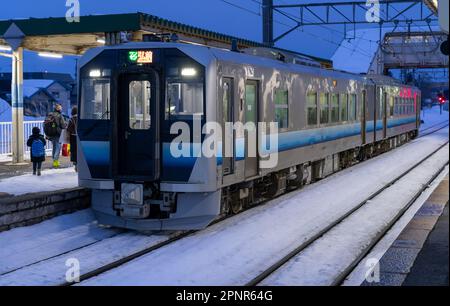 Un treno JR East GV-E400 in inverno alla stazione di Kawabe nella prefettura di Aomori, Giappone. Foto Stock