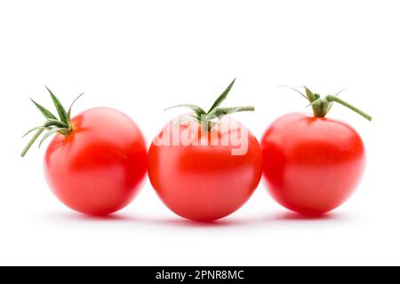 Piccoli pomodori ciliegini rossi su sfondo bianco. Foto Stock