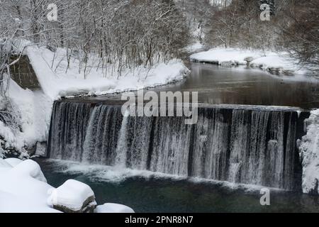 Una diga sul fiume Obonai nella prefettura di Akita, Giappone, vista in inverno da un treno JR East sulla linea Akita Shinkansen. Foto Stock