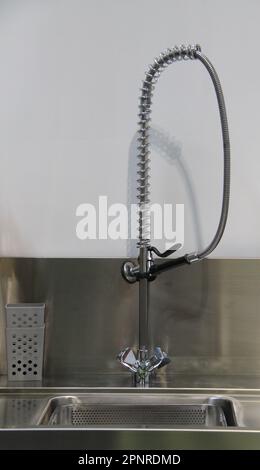 Un rubinetto miscelatore verticale su un'unità di piegatura in acciaio inossidabile. Foto Stock