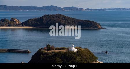 Faro di Nabeshima sul Mare interno di Seto in Giappone, visto da un treno che attraversa il Ponte Grande Seto. Foto Stock