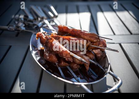 Grigliare gli spiedini con pollo marinato in un recipiente di metallo. Foto Stock